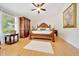 Charming bedroom features a decorative ceiling fan and lovely hardwood floors at 21000 Exeter Ct, Brooksville, FL 34601