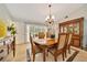 Elegant dining room featuring a wooden table, chandelier, and large windows that provide ample natural light at 21000 Exeter Ct, Brooksville, FL 34601