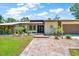 Charming home exterior with brick walkway leading to a glass double-door entrance and manicured garden at 21000 Exeter Ct, Brooksville, FL 34601