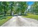 Long driveway leading to a gated property entrance with decorative pillars and mature trees at 21000 Exeter Ct, Brooksville, FL 34601