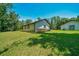 Exterior home view featuring a large lawn and lush perimeter landscaping at 21000 Exeter Ct, Brooksville, FL 34601