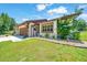 Exterior view of the home with a well-kept lawn and a charming facade featuring stone and manicured landscaping at 21000 Exeter Ct, Brooksville, FL 34601