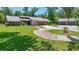 Spacious front yard featuring a circular driveway leading to a home with stone accents and lush landscaping at 21000 Exeter Ct, Brooksville, FL 34601