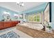 Bright main bathroom with double sinks, soaking tub, patterned rugs, and a window for natural light at 21000 Exeter Ct, Brooksville, FL 34601