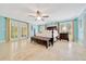 Spacious main bedroom with a four-poster bed, tile floors, and French doors leading to the outdoors at 21000 Exeter Ct, Brooksville, FL 34601