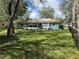 View of a fenced backyard with a well-maintained lawn and mature trees at 2158 Clayton Ave, Spring Hill, FL 34609