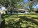 Spacious backyard featuring a manicured lawn, mature trees, and partial fencing at 2158 Clayton Ave, Spring Hill, FL 34609
