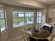 Sunlit dining area features a wood table and views of the outdoors through multiple windows at 2158 Clayton Ave, Spring Hill, FL 34609