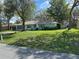 Inviting home with lush green lawn and mature shade trees offering curb appeal at 2158 Clayton Ave, Spring Hill, FL 34609