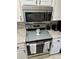 Stainless steel oven and microwave appliances with white cabinetry for a modern kitchen look at 2158 Clayton Ave, Spring Hill, FL 34609
