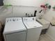 Functional laundry room with washer, dryer, sink, and shelving for storage at 2158 Clayton Ave, Spring Hill, FL 34609