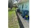 Home exterior featuring air conditioning unit, trash bins, and fenced yard access at 2158 Clayton Ave, Spring Hill, FL 34609
