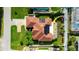 Aerial view showcasing the home's layout, solar panels, screened pool, fenced yard, and surrounding greenery at 21820 Carson Dr, Land O Lakes, FL 34639