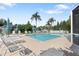 Community pool with multiple lounge chairs and patio umbrellas on a sunny day at 21820 Carson Dr, Land O Lakes, FL 34639