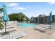 Community pool featuring lounge chairs and umbrellas on a sunny day with a screened in area at 21820 Carson Dr, Land O Lakes, FL 34639