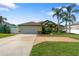 Well-maintained home with a large driveway and lush green landscaping at 21820 Carson Dr, Land O Lakes, FL 34639