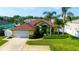 Bright yellow single Gathering home with lush landscaping, a brown roof, and an attached two car garage at 21820 Carson Dr, Land O Lakes, FL 34639