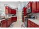 Well-equipped kitchen with vibrant red cabinetry, modern appliances, and ample counter space at 21820 Carson Dr, Land O Lakes, FL 34639
