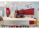 Bright kitchen features red cabinets, modern appliances, and a large counter with seating, perfect for entertaining at 21820 Carson Dr, Land O Lakes, FL 34639
