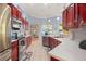 Beautiful kitchen with stainless steel appliances, red cabinets, and tile floors, offering a modern and stylish space at 21820 Carson Dr, Land O Lakes, FL 34639