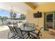 Enclosed patio with a glass table, seating, and mounted TV for outdoor entertainment at 21820 Carson Dr, Land O Lakes, FL 34639