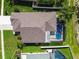 Aerial view of house showing roof, screened in pool, lawn and landscaping at 22431 Willow Lakes Dr, Lutz, FL 33549