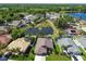 Aerial view of homes surrounding community pond with lush greenery, lake in distance at 22431 Willow Lakes Dr, Lutz, FL 33549