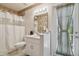 Bathroom with vanity, commode, and shower with floral wallpaper accent at 22431 Willow Lakes Dr, Lutz, FL 33549