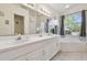 Bathroom features a double vanity, soaking tub under an arched window, and separate shower at 22431 Willow Lakes Dr, Lutz, FL 33549