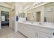Bathroom features a double vanity and a doorway leading to a bedroom at 22431 Willow Lakes Dr, Lutz, FL 33549
