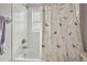 Clean bathroom with white tiled shower and dragonfly patterned shower curtain at 22431 Willow Lakes Dr, Lutz, FL 33549