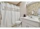 Bathroom with vanity, commode, and shower with floral wallpaper accent at 22431 Willow Lakes Dr, Lutz, FL 33549