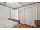 Bedroom featuring wood floors, a wood bed, and a large closet with white doors at 22431 Willow Lakes Dr, Lutz, FL 33549