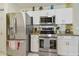 Kitchen featuring stainless steel appliances, white cabinets, and granite countertops at 22431 Willow Lakes Dr, Lutz, FL 33549