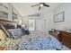 Main bedroom with a ceiling fan, ensuite bathroom access, and a decorative bench at the foot of the bed at 22431 Willow Lakes Dr, Lutz, FL 33549