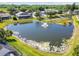Aerial view of a pond with a fountain and surrounding homes in a residential neighborhood at 22431 Willow Lakes Dr, Lutz, FL 33549