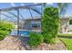 Backyard view of pool with screen enclosure and tropical landscaping at 22431 Willow Lakes Dr, Lutz, FL 33549