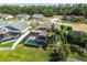Aerial view of screened pool and landscaped backyard with palm trees in a residential neighborhood at 22431 Willow Lakes Dr, Lutz, FL 33549