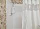 Bathroom with tile shower and floral wallpaper accent at 22431 Willow Lakes Dr, Lutz, FL 33549