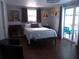 Cozy bedroom featuring hardwood floors, neutral walls, and sliding glass doors to the outdoor pool area at 3207 Jarvis St, Holiday, FL 34690