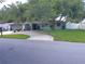 Charming single-story home featuring a well-maintained lawn, mature trees, and a curved driveway leading to a two-car garage at 3207 Jarvis St, Holiday, FL 34690