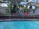 Inviting screened-in pool area with colorful landscaping offering a relaxing outdoor space at 3207 Jarvis St, Holiday, FL 34690