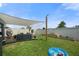 Backyard features a shade-covered patio with modern furniture and a lush, green lawn with planter boxes at 33592 Barberry Leaf Way, Wesley Chapel, FL 33543