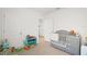 Well-organized Bedroom featuring a grey crib and dresser, with multiple doorways at 33592 Barberry Leaf Way, Wesley Chapel, FL 33543