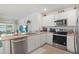 Well-lit kitchen featuring stainless steel appliances, stone countertops, and modern white cabinets at 33592 Barberry Leaf Way, Wesley Chapel, FL 33543