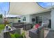 Outdoor patio with modern seating, shade sail, and views of the fenced backyard at 33592 Barberry Leaf Way, Wesley Chapel, FL 33543