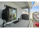 Covered patio with sliding glass doors, grill, and outdoor seating offering a relaxing space at 33592 Barberry Leaf Way, Wesley Chapel, FL 33543