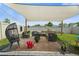 Outdoor patio seating area with stylish furniture, a shade sail, and a charming hanging egg chair at 33592 Barberry Leaf Way, Wesley Chapel, FL 33543