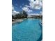 Resort-style pool with sun loungers and shade, perfect for relaxation on a sunny day at 33592 Barberry Leaf Way, Wesley Chapel, FL 33543