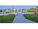 Scenic backyard view showcasing a concrete walkway leading to a private boat dock and waterfront at 3546 Flamingo Blvd, Hernando Beach, FL 34607